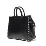 Cartera estructurada de cuero vacuno en color negro, de formato mediano con detalle de tachas metálicas en todo el contorno. Cuenta con asas cortas fijas para llevar en mano y una correa larga regulable y desmontable. Presenta cierre superior con cremallera metálica, costuras decorativas en los paneles frontales, herrajes plateados y bolsillo interior con cierre.