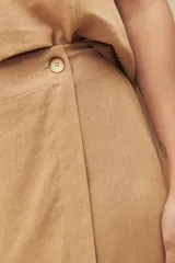 Short de lino y viscosa en color negro, con diseño de cruce delantero tipo pollera y detalle de botón lateral.