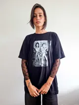 Remera de manga larga confeccionada en microtul transparente con diseño de lunares flocados en color negro, con cuello redondo.