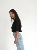 Top negro de tejido de punto con mangas cortas y bordado en el frente.