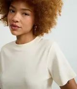 Remera básica de manga corta y cuello redondo, confeccionada en algodón interlock. Presenta un diseño liso sin estampados, ideal para uso diario.