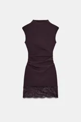 Vestido corto de tejido elástico en color bordó, con cuello redondo, diseño sin mangas y detalle de frunces en la cintura. El bajo presenta una terminación en encaje combinado a tono.