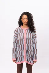 Saco de punto con diseño de bloques geométricos en tonos celeste y marrón, con cuello redondo, cierre frontal de botones y terminaciones en color rosado.