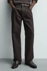 Jeans flare fit de denim negro, con tiro medio, corte ajustado en la parte superior y ligeramente acampanado desde la rodilla. Diseño de cinco bolsillos y cierre frontal con botones.