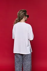 Remera de algodón con corte boxy fit, silueta amplia, hombros caídos y aberturas laterales.