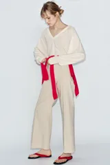 Jeans de tiro alto confeccionados en mezcla de algodón, con diseño de pierna ancha y costura marcada en el delantero. Presenta cintura con trabillas, cierre frontal con cremallera, botón y gancho metálico, y bolsillos de plastrón en la espalda.