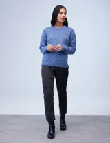 Buzo de lana melange color tostado, con cuello redondo y mangas largas.