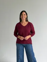 Sweater de punto en color bordó, con escote en V, mangas largas y diseño de corte recto con dobladillo ligeramente más largo en la parte posterior.