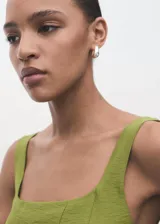 Vestido midi de corte evasé en color verde oliva, con escote cuadrado, tirantes anchos y costuras decorativas verticales que realzan la silueta. Cuenta con cierre de cremallera en la parte posterior y forro interior.