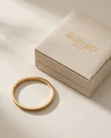 Pulsera tipo esclava rígida de acero con baño de oro, con diseño de banda central texturizada y bordes lisos.