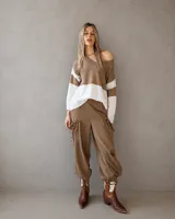 Sweater de punto liviano con diseño de bloques de color en tonos marrón y blanco, escote en V y mangas largas.