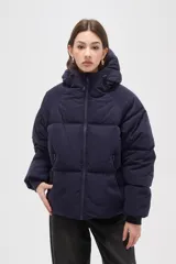 Campera puffer de corte holgado, color azul marino, con capucha ajustable, cierre frontal y bolsillos laterales con cierre. Presenta diseño capitoneado y puños elásticos.