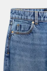 Jeans mom fit de tiro alto y diseño tobillero, confeccionados en denim de lavado medio con cinco bolsillos, trabillas para cinturón y cierre frontal con cremallera y botón metálico.