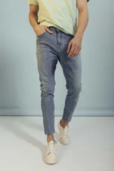 Pantalón de jean corte slim fit, color azul lavado, con cierre frontal y bolsillos laterales.
