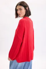 Sweater de punto liso en color rojo, con cuello redondo y diseño holgado de manga larga.