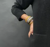 Pulsera de resina flexible con diseño trenzado y acabado brillante, con relleno de lámina metálica en tonos dorados, plateados y cobrizos.