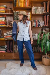 Camisa sin mangas de corte clásico, color celeste con sutiles rayas verticales, cuello camisero y bolsillos frontales con solapa.