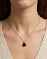 Collar de acero con baño de oro, compuesto por una cadena fina de eslabones y un dije circular con piedra central de color negro.