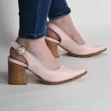 Stiletto destalonado de cuero color rosado, con punta fina, taco ancho de madera y tira ajustable con hebilla metálica en el talón.
