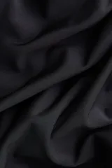 Top entallado de punto elástico con diseño asimétrico de hombros descubiertos y detalle de drapeado mediante costuras fruncidas.