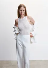 Top sin mangas de punto fino con diseño de canalé y textura desagujada. Presenta cuello redondo y un corte entallado.