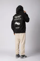 Buzo canguro oversize de algodón frizado con efecto gastado, capucha y bolsillo frontal tipo canguro. Presenta estampa gráfica sutil en el pecho.