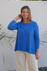 Sweater de punto color azul, con cuello redondo, manga larga y corte holgado con ruedo asimétrico.