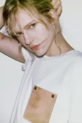 Camiseta blanca de algodón, corte regular, cuello redondo y manga corta, con bolsillo cuadrado de tejido efecto piel color camel en el pecho.