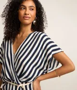 Blusa de viscolino a rayas verticales azul marino y blanco, con escote en V cruzado, mangas cortas y cinturón de cuerda en la cintura.