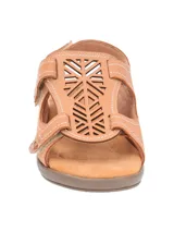 Sandalia de cuero color tostado con diseño de calados geométricos en la parte superior. Cuenta con tiras ajustables con velcro, plantilla acolchada y suela de plataforma baja.