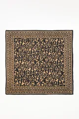 Pañuelo cuadrado estampado con diseño étnico o ikat en tonos negro y camel/marrón claro.