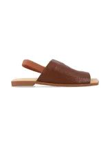 Sandalia plana de cuero graneado color marrón chocolate, con tira elástica en el talón, punta cuadrada y suela baja.