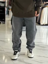 Pantalón de jean gris con efecto deslavado, de corte oversize y diseño holgado con piernas anchas.
