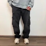 Pantalón tipo jean cargo de corte recto y tiro medio, en color azul claro lavado. Presenta bolsillos laterales con solapa y cierre de botón y cremallera.