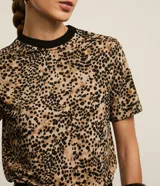 Blusa slim de mangas cortas, confeccionada en viscosa, poliéster y elastano, de la marca Cortelle. Presenta cuello redondo de punto contrastante negro y estampa de animal print de leopardo.
