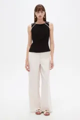 Musculosa sin mangas de viscosa, color negro con vivos blancos en los hombros, al cuerpo, con cierre y cuello a la base.