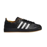Championes Adidas Superstar II, color negro con las tres tiras blancas características, detalles en dorado y suela de goma marrón.