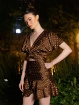 Top marrón con lunares blancos, escote en V, mangas cortas amplias y lazo central.