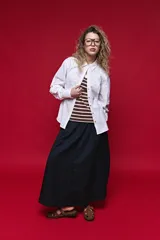 Camisa blanca de manga larga con volumen y estructura, cierre frontal con botones y lazo ajustable en la cintura que realza la silueta.