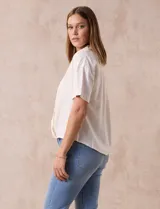 Blusa color blanco de lino, con cuello con solapa y escote en V. Delantera cruzada y mangas cortas. Marca Cable & Gauge.