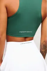 Top deportivo negro, estilo crop top, con cuello polo y escote en V. Presenta tirantes anchos y corte ajustado al cuerpo.