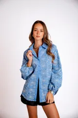 Camisa color crema con bordado de flores blancas, de manga larga abullonada y cuello clásico.