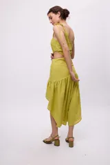 Vestido azul con bretel fino, escote asimétrico de un hombro, corte a la cintura con recorte en el lateral y falda midi con volados irregulares.