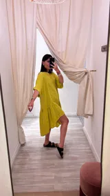 Vestido celeste de lino con corte asimétrico, más corto adelante que atrás, y diseño holgado.