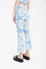 Pantalón celeste con estampado floral en blanco, corte cropped y tiro alto.