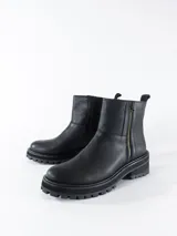 Bota corta negra de cuero con cierre lateral dorado, suela track y plataforma baja.