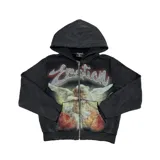 Campera con cierre frontal, confeccionada en algodón con efecto acid wash en color negro. Presenta un diseño gráfico central de un ángel con arco y flecha, acompañado por la palabra 'Emotion' escrita con apliques de strass.