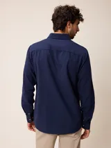Camisa de manga larga confeccionada en algodón oxford, con cuello abotonado y cierre frontal de botones. Presenta un diseño clásico y minimalista con un pequeño logo bordado en el pecho.