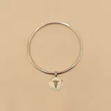 Brazalete tipo esclava de alambre redondo en plata 925, con medalla colgante circular que presenta el símbolo de la medicina en combinación de plata y oro 9k.