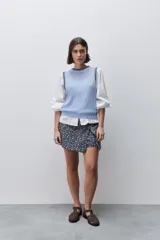 Short cruzado de tiro medio confeccionado en algodón, con diseño que imita una falda en el delantero. Presenta cierre lateral invisible y estampado floral sutil.
